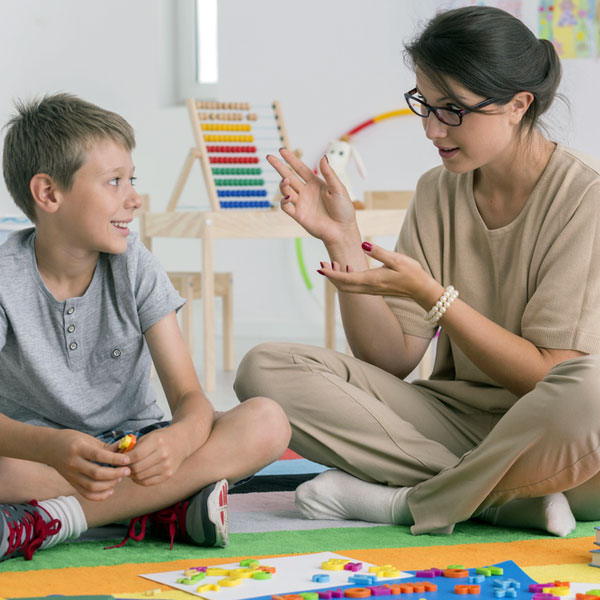 Female counsellor with boy in classroom